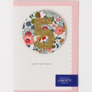 Glittery Liberty birthday badge with floral 'Betsy Blue' print and gold number 5 on a birthday card.