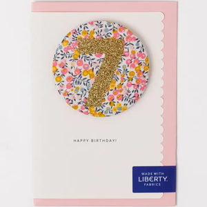 Glittery Liberty birthday badge with number 7 in Wiltshire Bud print, attached to A6 portrait card, perfect for 7th birthday celebrations