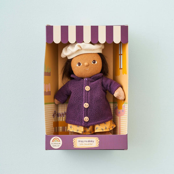 Olli Ella Dress Me Dinky Lila Lavender doll in a purple coat and white beanie, ready for adventure in her colorful packaging.