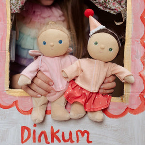 Two adorable Dinkum dolls in cozy outfits, perfect for imaginative play and cuddles, held by a child.