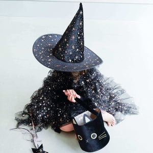 Child wearing a Mimi & Lula Aurora Witch Hat and matching starry outfit, holding a black cat-themed bag. Perfect for Halloween magic and fun!