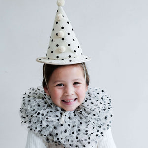 Little girl smiling in Mimi & Lula Clown Set, featuring a polka dot clown hat and matching neck ruff.