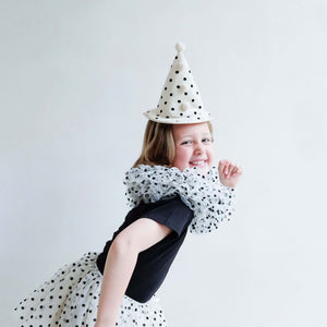 Child wearing Mimi & Lula clown set with polka dot hat and neck ruff, playful posing, tutu skirt sold separately.