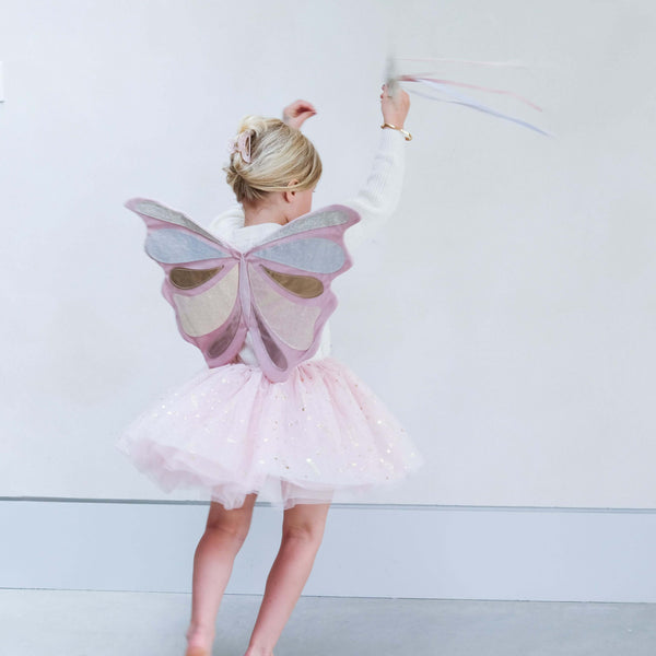 Child wearing Mimi & Lula Emmelina Fairy Wings - Pink, twirling with joy in a sparkly tutu.