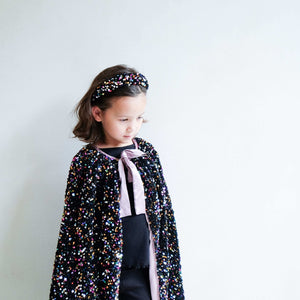 Young girl wearing Mimi & Lula Jazzy Sequin Alice cape and headband, looking stylish and confident