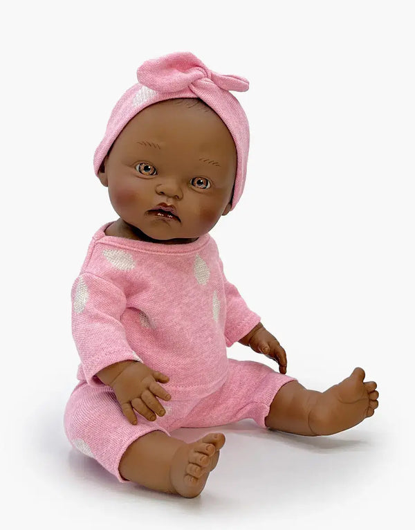 Minikane Cuties Betty doll in pink top and leggings, complete with matching headband, perfect for imaginative play.