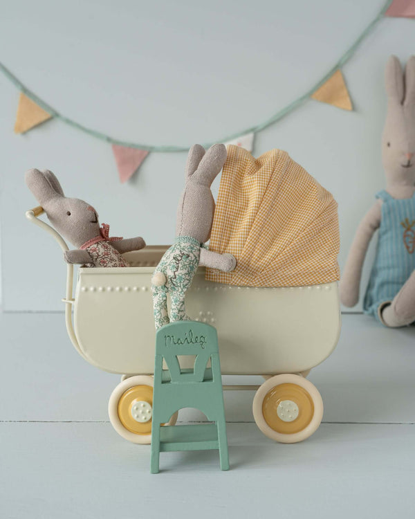 Maileg mint high chair with baby mouse beside toy pram with rabbit dolls in nursery scene